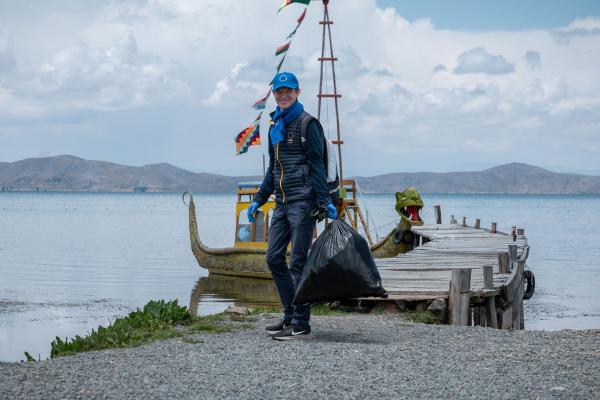 2024 EUBeachCleanup Huatajata, Bolivia, one man with a black bin bag